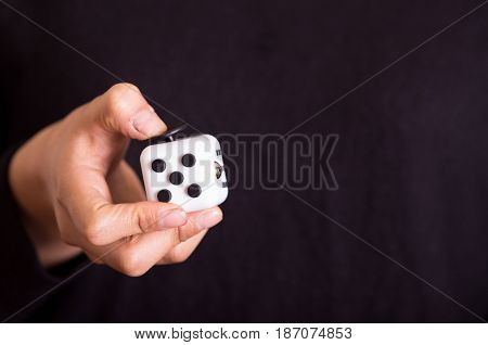 Quito, Ecuador - February 10, 2017: Man holding a Fidget Cube stress reliever, in black background.
