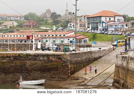 SPAIN CANTABRIA COMILLAS - JULY 7 2016: Port and marine during an outflow. A view of the city from port in foggy summer day after a rain