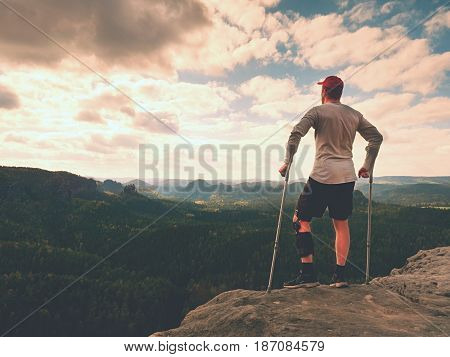 Happy Man With Broken Leg In Immobilizer And Medicine Pole Stay Finnaly On  Peak.