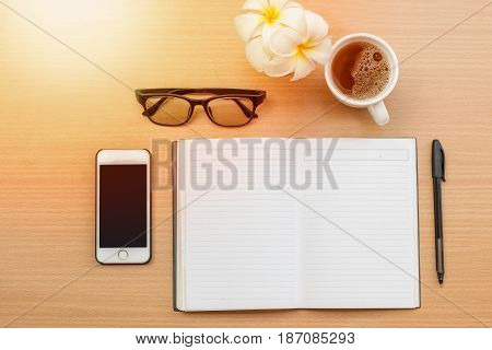 sunrise office with wooden table and laying on it with coffie
