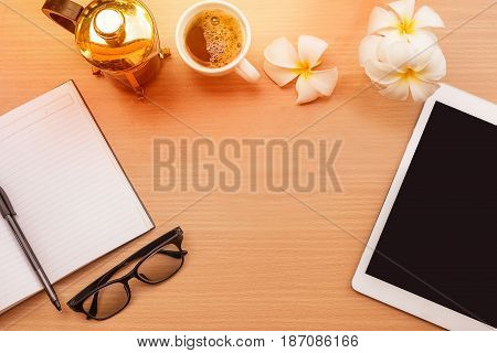 sunrise office with wooden table and laying on it with coffie