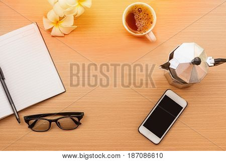 sunrise office with wooden table and laying on it with coffie