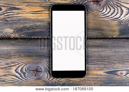 Mobile phone with blank screen mock up isolated on wood table background. Smartphone on wood table. Smartfone white