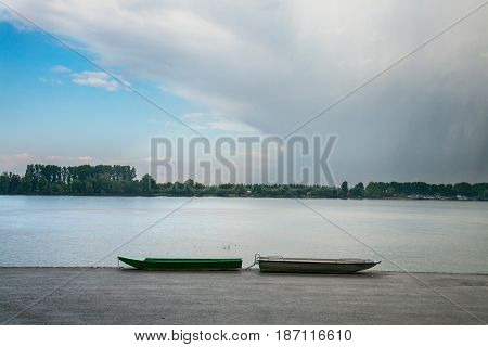 Two fishing boats on Zemun Quay (Zemunski kej) in a cloudy afternoon over the Danube river Belgrade capital city of Serbia