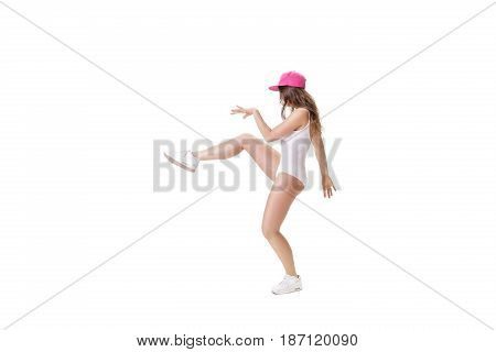 young sports woman in white bodysuit and pink hat dancing on a white background