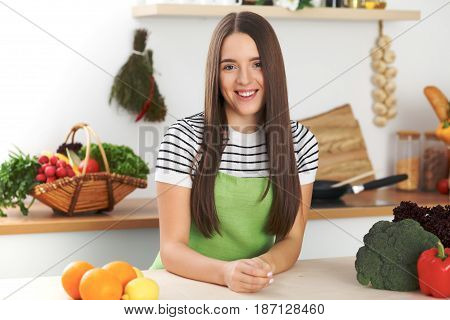Young woman is making online shopping by tablet computer and credit card. Housewife found new recipe for cooking in a kitchen.