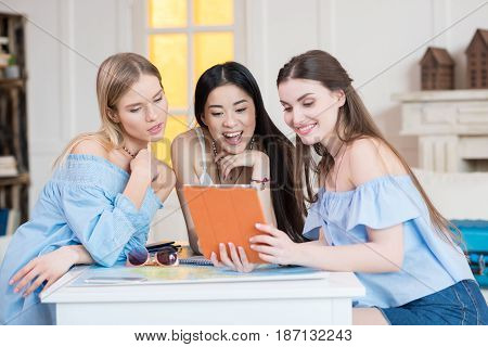 Young Women Travelers Holding Digital Tablet While Sitting At Room, Best Friends Girls
