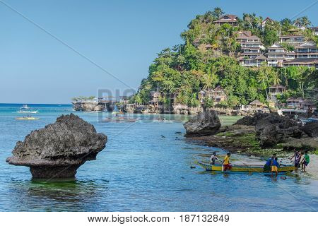 Boracay, Philippines - March 14, 2016: Fishermen and boats  at famous Diniwid Beach on Boracay Island, Philippines