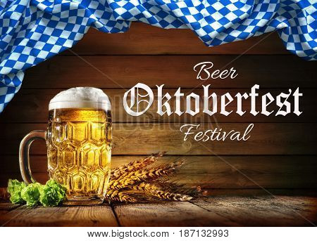 Oktoberfest beer with wheat  and hops on wooden table