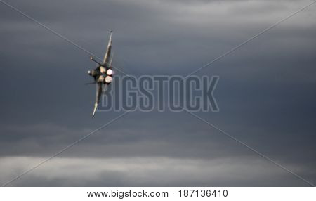 Albion Park, Australia - May 6, 2017. Silhouette of F18 Hornet fighter aircraft in flight. Clouds in the background. Wings Over Illawarra is an annual air show held at Illawarra Regional Airport.