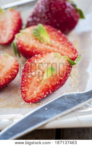 strawberries cut with sugar and mint close up