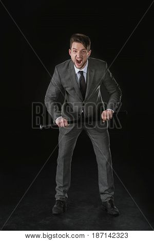 Angry Businessman Holding Baseball Bat And Screaming Isolated On Black