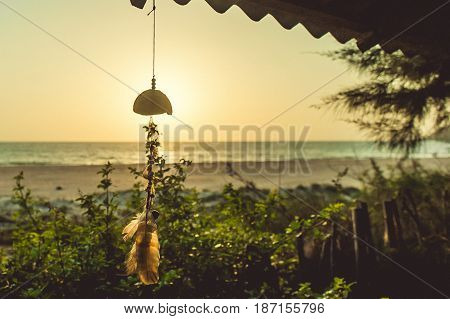 Amulet Of Coconut Shell And Feathers On The Sunset Background