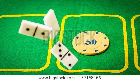 Board games are very popular all over the world bright green playing field for playing poker on it is a plastic chip and on top falls dominoes
