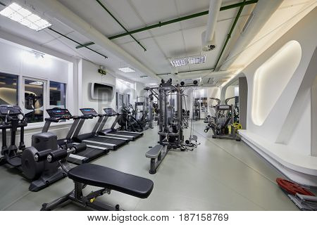 Modern gym room with plenty of fitness equipment.