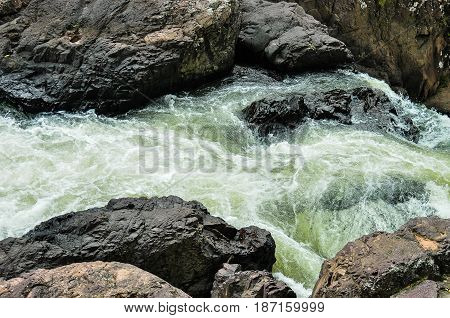 The waterfall flows through the rocks with speed.