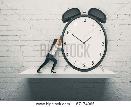 Abstract image of young woman pushing huge alarm clock placed on white shelf. Brick wall background. Time management concept. 3D Rendering