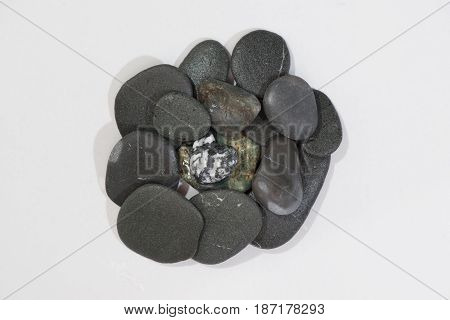 Stacked Rocks on a white background with color rocks on top