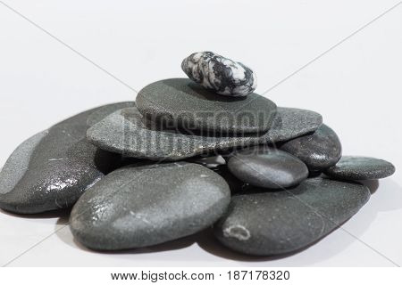 Stacked Rocks on a white background with color rocks on top
