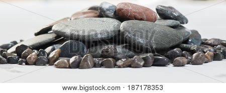 Stacked Rocks on a white background with color rocks on top
