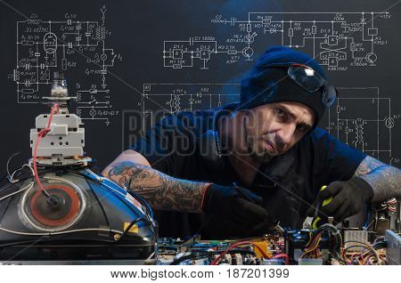 man is engaged in repair of electronics