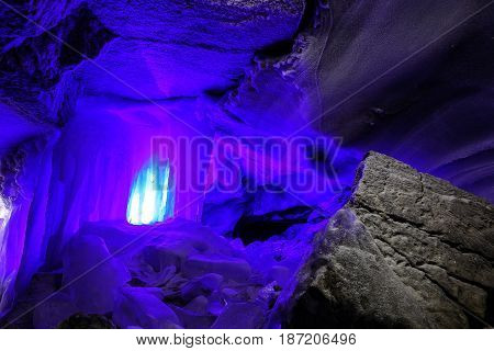 ice stalactites blue color in the cave in the stunning texture of rock, covered with frost