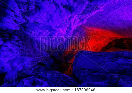 beautiful illuminated multicolored stalactites from karst cave.