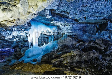 ice stalagmites in the blue light fantastic in a beautiful cave with numerous mining deposits