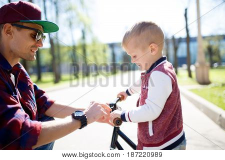 Dad with small son on bike ride in park