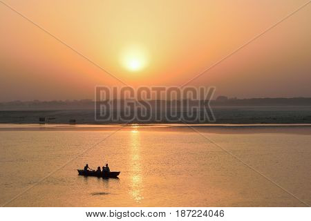 VARANASI, INDIA - May 7, 2017 : Tourists on wooden boats at Ganges river in Varanasi India taken on May 7, 2017 at Varanasi, India. Boat ride at Ganges river is famous travel activity in Varanasi