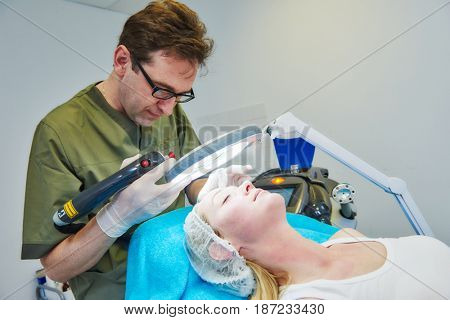 doctor cosmetologist examining woman skin