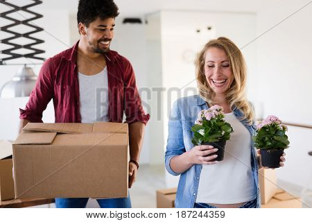 Young married couple Moving in new home and unpacking carboard boxes
