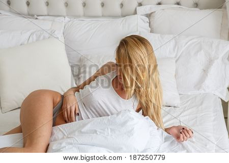 Beautiful girl sexy blonde posing on the bed in the morning, bed, room, interior, bedroom