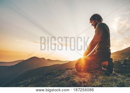 Man relaxing at sunset mountains Travel Lifestyle spiritual emotional meditating concept vacations outdoor harmony with nature landscape