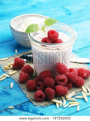 Beautiful appetizer pink raspberries fruit smoothie or milk shake in glass jar with berries background top view. Yogurt cocktail. Close up. Natural detox. Liquid ice cream.