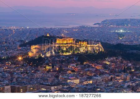 cityscape of Athens with illuminated Acropolis hill, Pathenon and sea at night, Greece