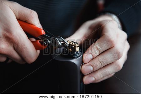 male master installs a coyle. Spiral for electronic evaporator and cigarette. Vape, vaping