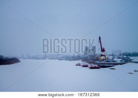 Gantry crane at the dock. Winter. The ice and snow on the river