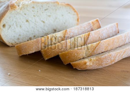 Slices and loaf of bread on wooden oak table top. Shallow depth of field.