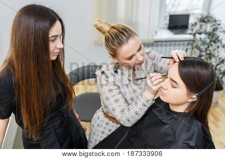 Makeup course at beauty school. Professional makeup artist conducts a master class. Make-up artist applying makeup