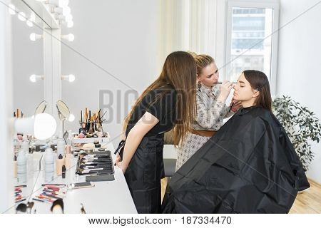 professional makeup artist conducts a master class. Make-up artist work in her studio. Visagiste applying makeup