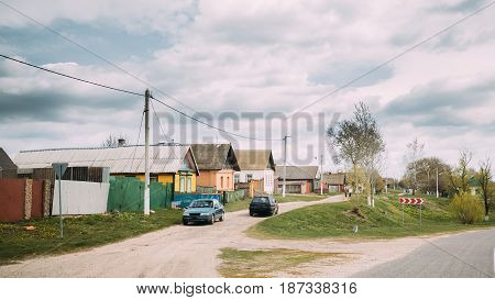 Belarus. Car Parking On Country Road On A Background Of Traditional Old Wooden Village House. Eastern Europe