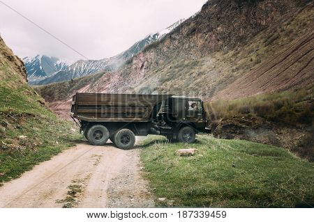 Truso Gorge, Georgia - May 22, 2016: Old Soviet Russian medium-duty truck Kamaz 53212 On Country Road In Summer Mountains Landscape In Truso Gorge, Kazbegi District, Mtskheta-Mtianeti Region, Georgia