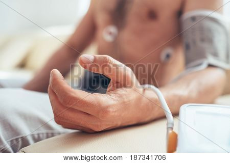 Close up man tested with Holter monitor hand with Sphygmomanometer