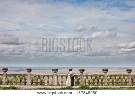 Couple admies blue clouded sky standing on the ruins