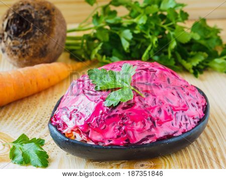 Close up view of homemade herring under a fur coat and ingredients. National festive Russian dish with beetroot. Served with fresh parsley