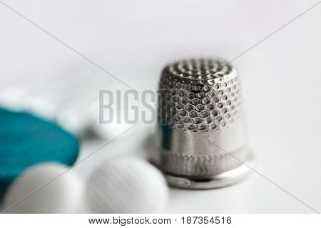 sewing, needlework and tailoring concept - close up of thimble
