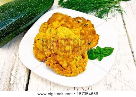 Indian chick-pea flour flatbreads with zucchini and fresh herbs, basil in a plate on a wooden boards background