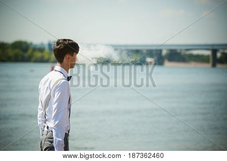 Young Skinny Man, Elegantly Stylishly Dressed In White Shirt, Trousers With Suspenders And Bow Tie.