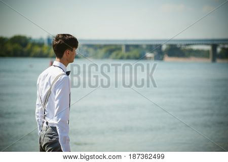 Young Skinny Man, Elegantly Stylishly Dressed In White Shirt, Trousers With Suspenders And Bow Tie.